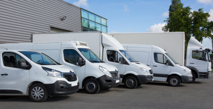 A commercial van with a company logo driving on a road, symbolizing commercial auto insurance.